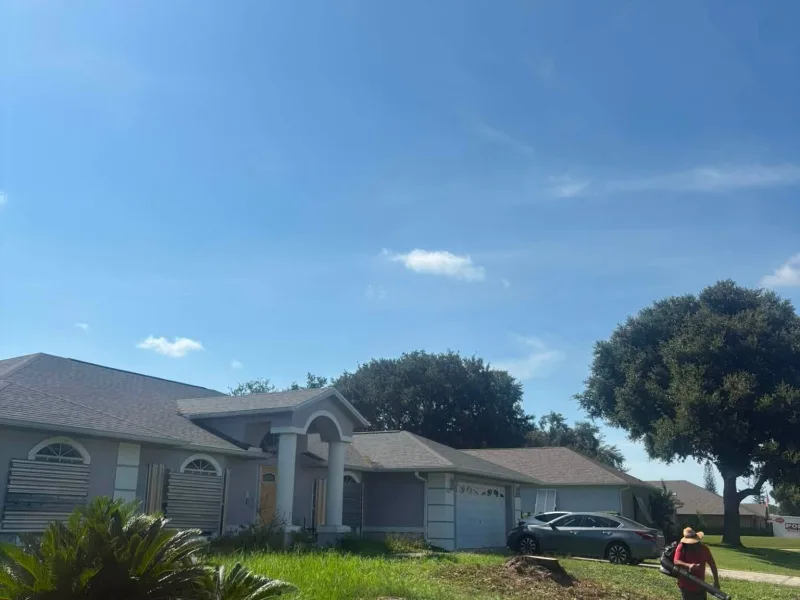 The same front yard with the pine gone and open sky above the house.