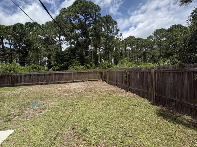 The same yard with the fence line clear and the back corner opened up.